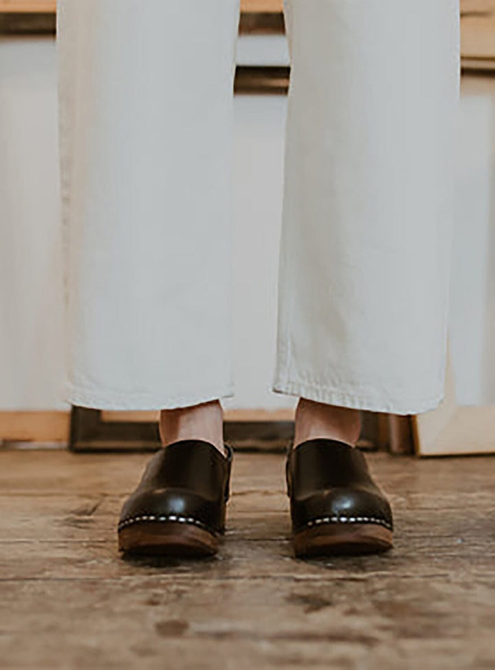 Calf view of model wearing Low Jord Clog from KIT + CLOGS  and cream linen trousers