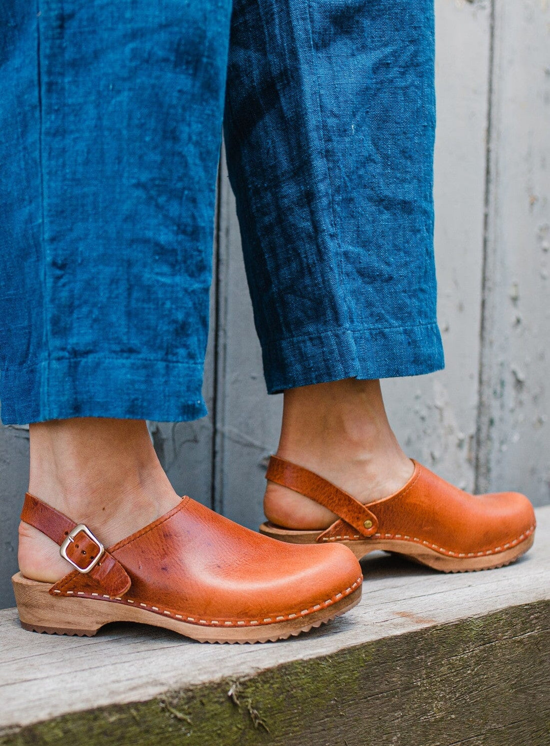 Calf view of model wearing Low Klassisk Clog with Strap from KIT + CLOGS  and deep indigo jeans